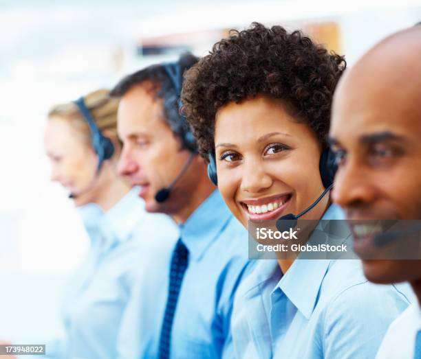 Female Telephonist Working With Her Colleagues Stock Photo - Download Image Now - Headset, White Collar Worker, 20-24 Years