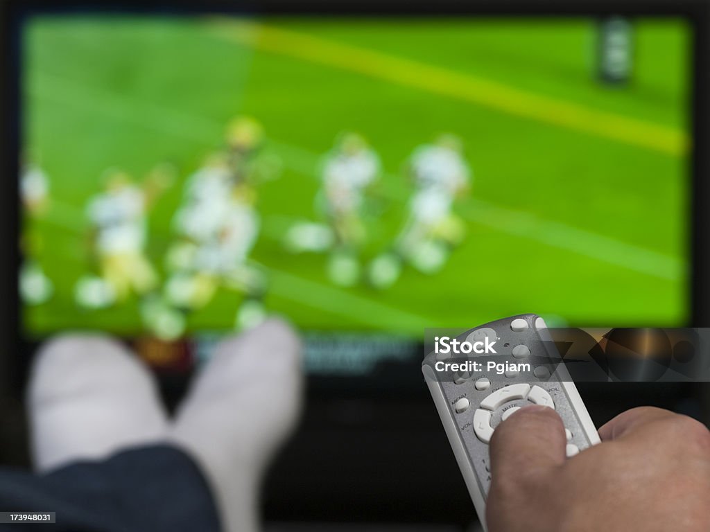 Hand hält eine Fernbedienung für den Fernseher - Lizenzfrei Amerikanischer Football Stock-Foto