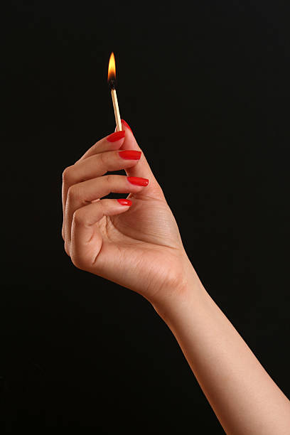 Holding match Woman hand with polished nail holding match lit match stock pictures, royalty-free photos & images
