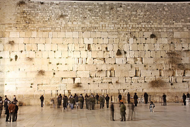 Western Wall "People, mostly soldiers praying at the holiest Jewish site - Western/Wailing wall at night" wailing wall stock pictures, royalty-free photos & images