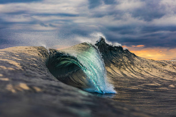 istock Powerful teal wave breaking in the ocean with a dark cloudy, sky 1739490449