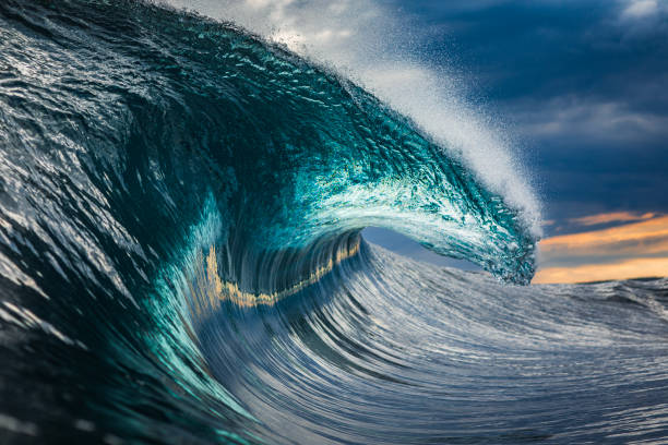 istock Powerful teal blue wave breaking in the ocean with a dark cloudy, sky 1739491506