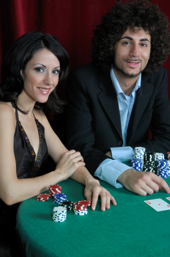 Handsome confident guy holding aces, cards and poker chips, looking at camera