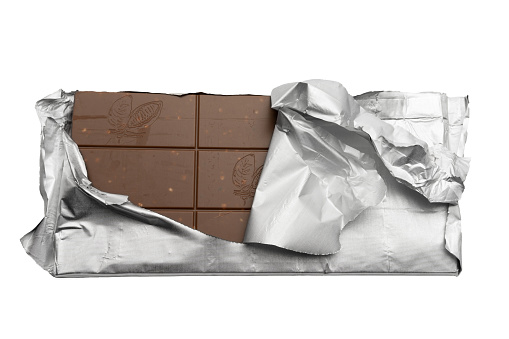 dark chocolate bar in a silver foil, partially unwrapped, on white background , with copyspace