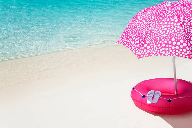 istock pink umbrella on the beach 173949804