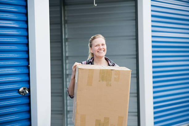 Woman With Box Outside Self Storage Unit stock photo