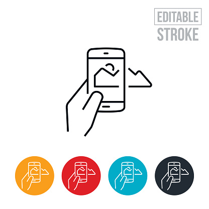 An icon of a hand holding a mobile phone and taking pictures of the mountains. The icon includes editable strokes or outlines using the EPS vector file.