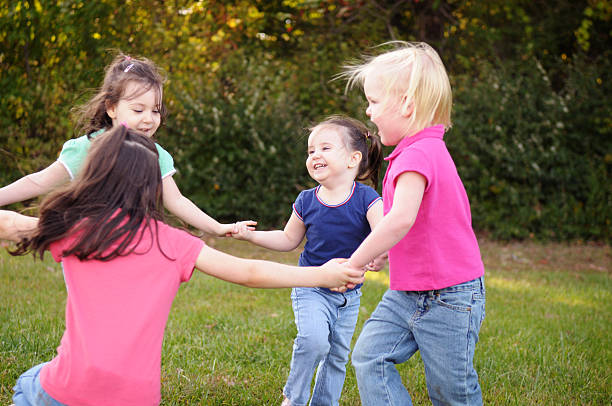 niñas jugando ronda infantil al aire libre - child dancing preschooler outdoors fotografías e imágenes de stock