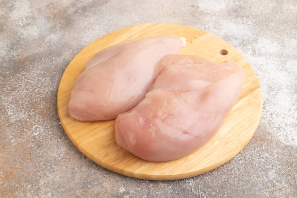 istock Raw chicken breast on brown concrete background. Side view 1739507675