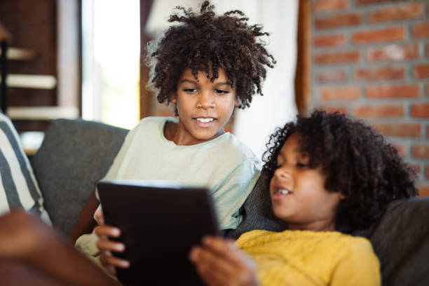 istock Small black kids using touchpad at home 1739529586