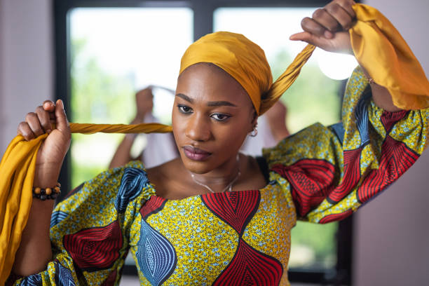istock Black woman putting on a headscarf 1739532031