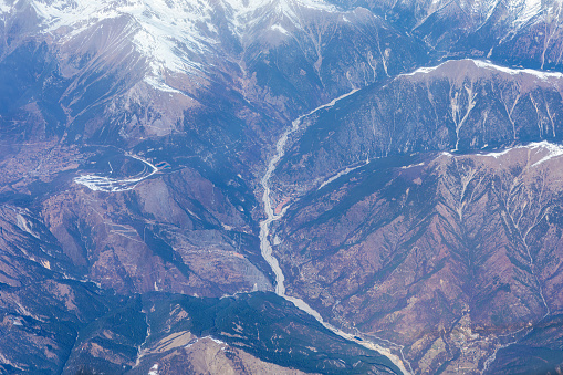 Aerial view of Alps mountains and river. View from airplane window