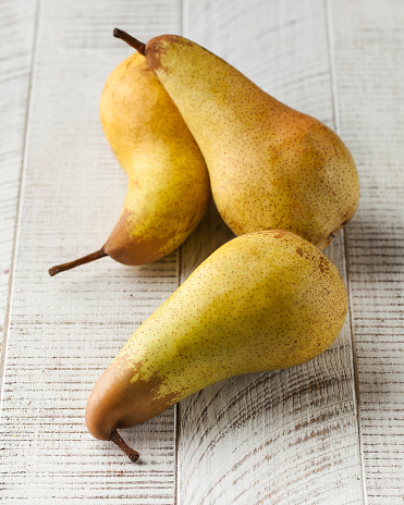 Ripe juicy pears on a white wooden background. The concept of healthy food, fruits