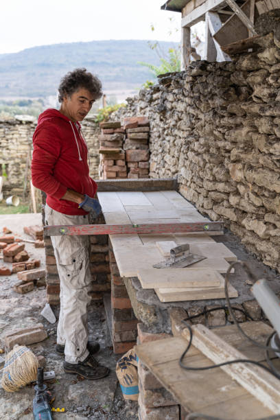 istock DIY home improvement. Man building stone barbeque. 1739697951