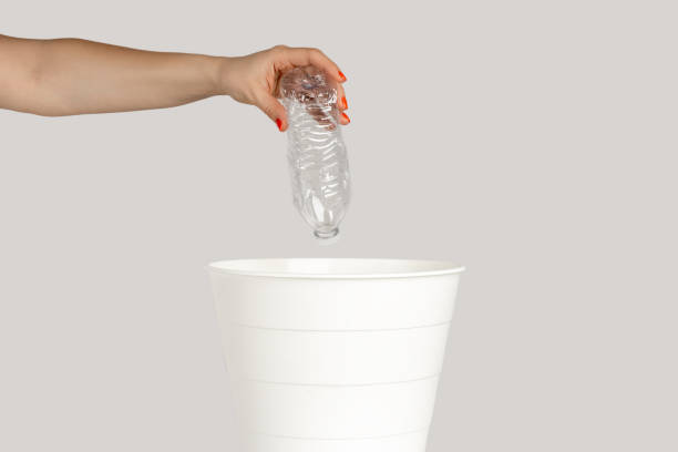 istock Woman hand throwing away empty plastic bottle, saving environment, recycle. 1739708995