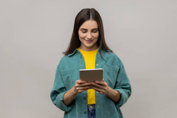 istock Woman working online, using tablet for checking social networks, looking at gadget display. 1739727456