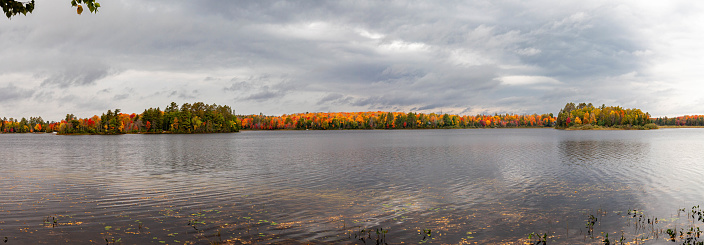 Colorful autumn trees on lake of the Falls in Mercer, Wisconsin, panorama