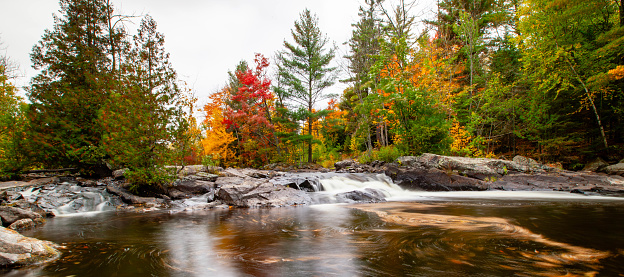 Waterfalls flowing into Lake of the Falls in Mercer, Wisconsin in September, panorama