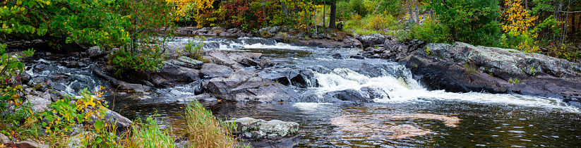 Waterfalls flowing into Lake of the Falls in Mercer, Wisconsin in September, panorama