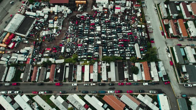 high angle of scrap auto yard in Melrose Park, Illinois USA. Pick and pull type. You come and pull parts then pay. Junk wrecked auto vehicles sorounded by a mobile home park. 4k Aerial
