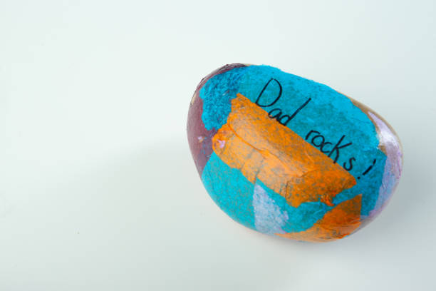 Child school art rock project for Father’s day on white table