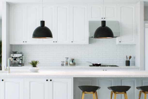 istock White kitchen with countertop as an accent. Kitchen work area with lamps, chairs and kitchen appliances. Kitchen with backsplash lighting blurred in the background. 3D rendering 1739824920