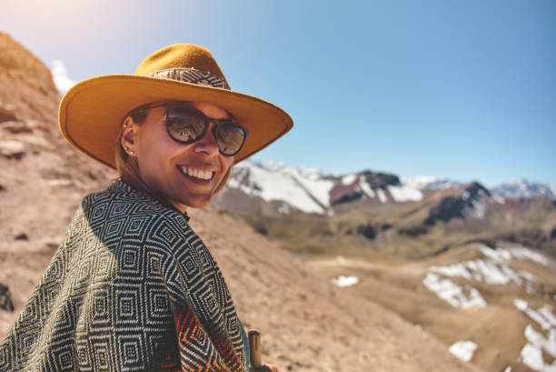 traveler hipster girl in hat with backpack exploring misty sunny mountains in clouds. space for text. travel and wanderlust concept.