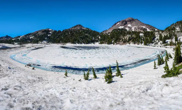 Frozen Lake Helen starting to thaw in the springtime in Lassen Volcanic National Park