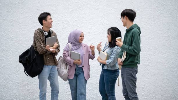 istock A group of happy, diverse Asian students are enjoying talking while standing outdoors together. 1739942123