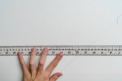 hand holding ruler with canvas background