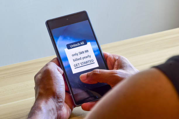 istock Man decision making moment for payment on in-app purchases notification to unlock all features in the mobile app. Selective focus. 1740054632