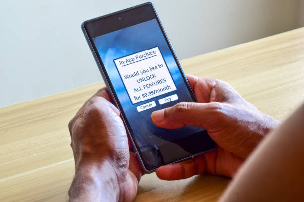 istock Man decision making moment for payment on in-app purchases notification to unlock all features in the mobile app. Selective focus. 1740055092