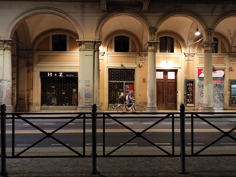 Man walking on the covered sidewalks in Bologna Historical centre by night, Emilia-Romagna, Italy.
