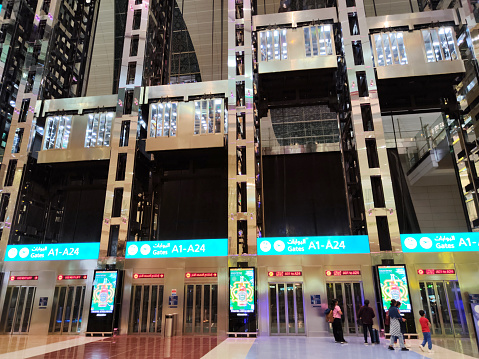 Travelers at elevators in Dubai International Airport, the primary international airport serving Dubai, United Arab Emirates, and the world's busiest airport by international passenger traffic.