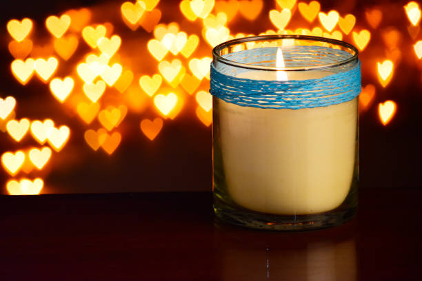 istock Closeup of scented candle jar at table with heart shape background 1740100370