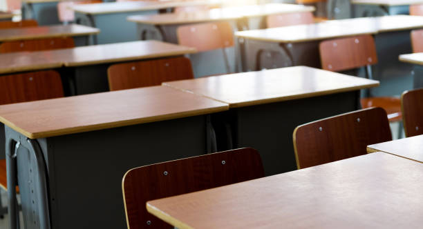 istock Empty classroom with chairs and desks in a line 1740120726