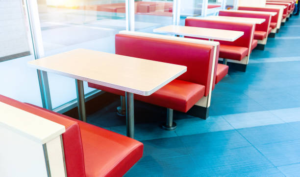 istock Empty fastfood restaurant interior with red chairs and table in a row 1740121250