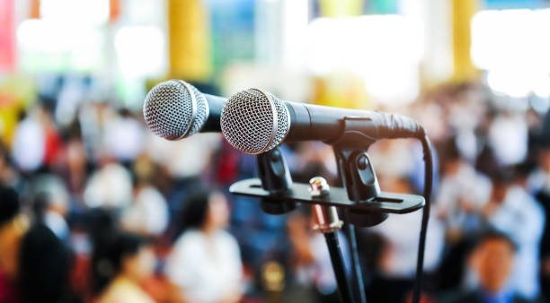 istock Closeup microphone in auditorium with blurred people in the background 1740127056