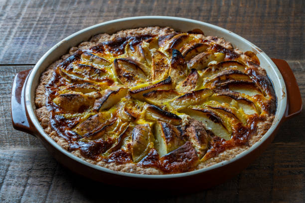 istock Apple pie in a ceramic baking dish on a wooden table. Homemade apple pie. Closeup 1740158012