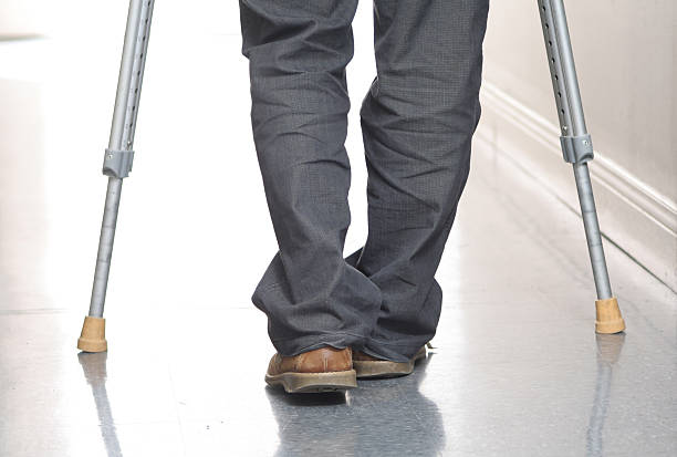 istock Man with jeans and brown loafers walks using crutches 174017915