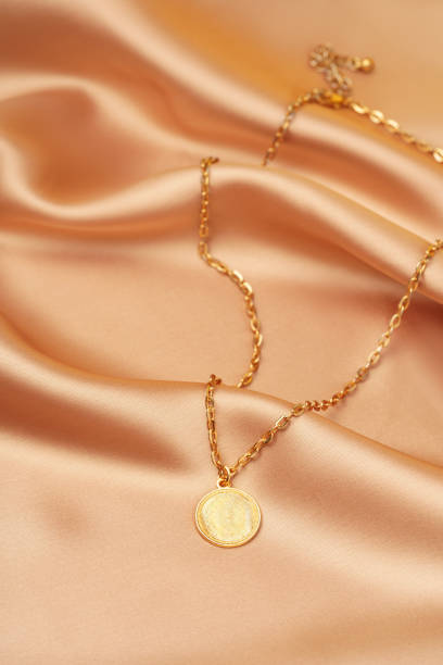 istock Golden necklace with pendant on silk background 1740195831