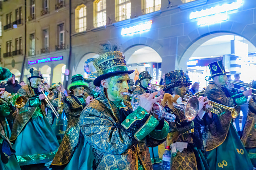 Bern, Switzerland - February 23, 2023: Guggenmusik band in costumes march in the street, part of the carnival of Bern, Switzerland