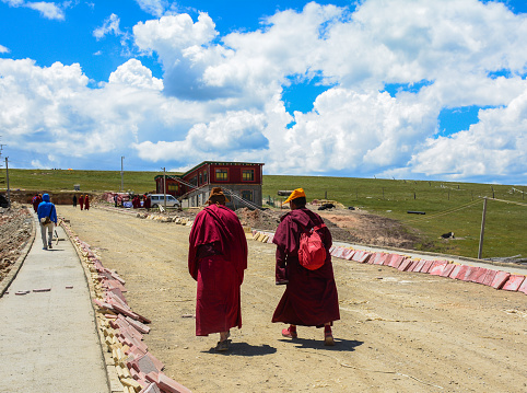 Sichuan, China - Aug 18, 2016. Tibetan monks walking on street near Yarchen Gar in Sichuan. Yarchen Gar is the largest concentration of nuns and monks in the world.