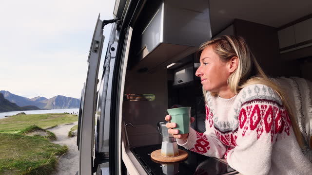 Slow Motion: Woman inside camper van making coffee in the morning