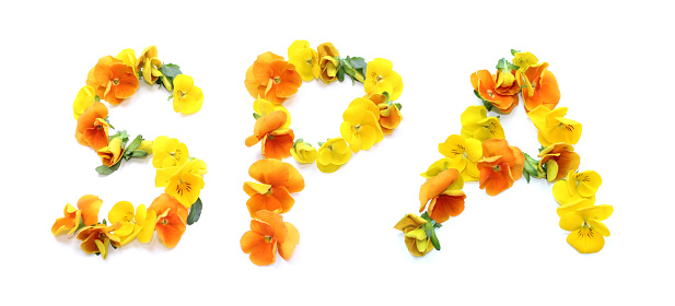 The word SPA is made of yellow and orange flowers. The floral lettering can be used as poster, greeting card and wellness spa relaxation or for invitation. Real flowers isolated on white background. capital letters S P A