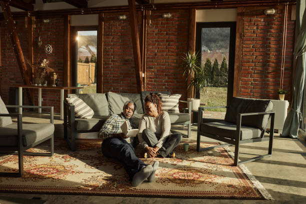 Black senior couple reading a book at home.