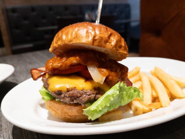 istock cheese hamburger. A dish with bacon, cheese, patty, and salsa sauce sandwiched between buns. 1740222104