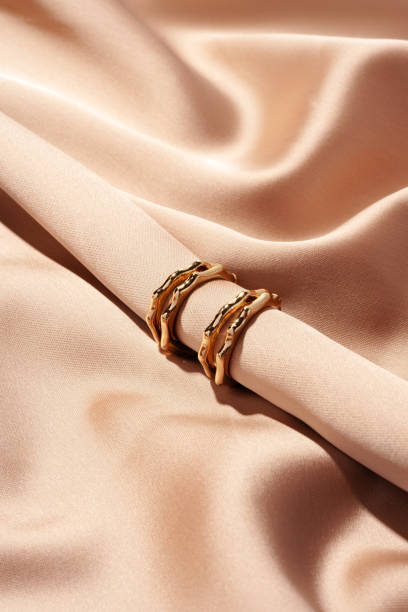 istock Golden earrings on a silk background close up 1740236293