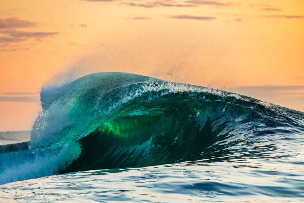 istock Powerful wave breaking in the ocean with golden sky at dusk 1740249613