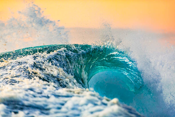 istock Powerful wave breaking in the ocean with golden sky at dusk 1740250121